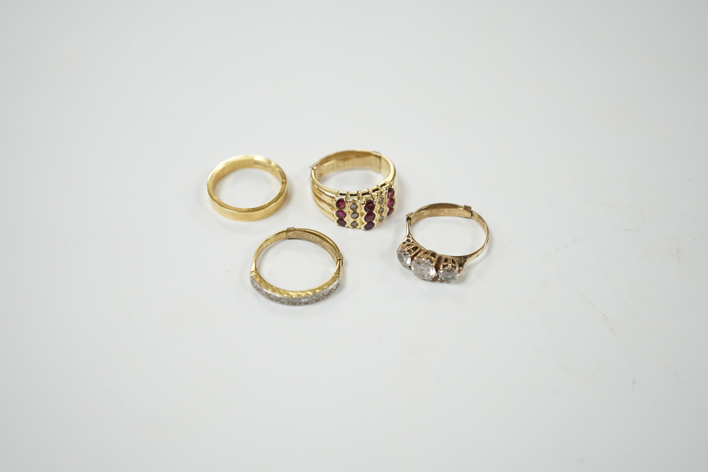 An 18ct and diamond chip set half hoop ring, size L/M, an 18ct gold band and two 9ct and gem set rings. Condition - fair